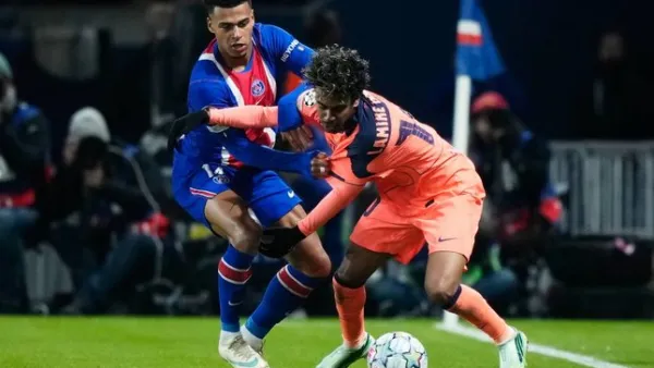 Pemain Barcelona Lamine Yamal mendapat kawalan dari pemain PSG Desire Doue dalam pertandingan Liga Champions, Rabu (21/10/2026). (c) AP Photo/Teresa Suarez